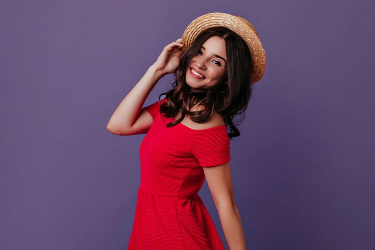 Mulher de vestido vermelho sobre fundo violeta