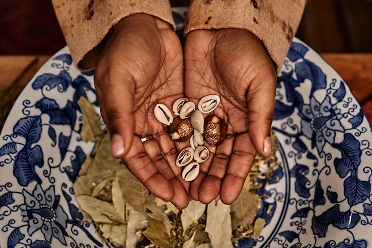 Mãos com Búzios antes de serem lançados