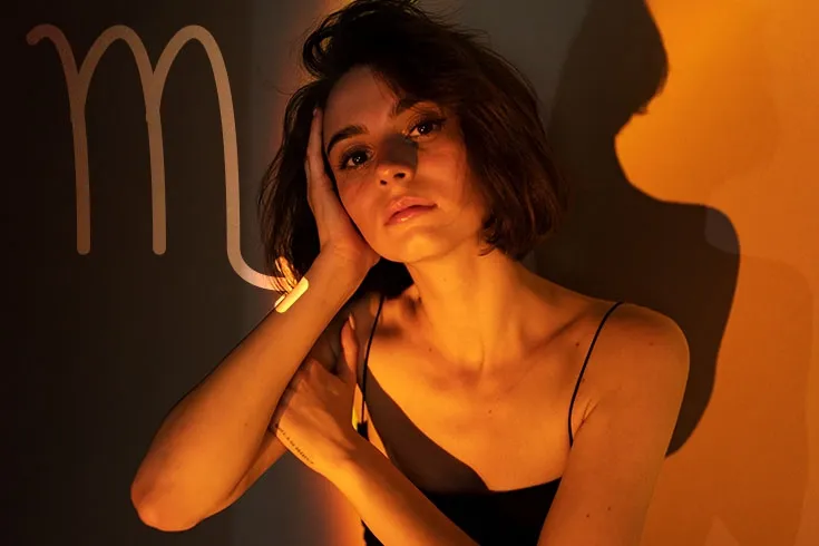 Mulher misteriosa à meia-luz, com símbolo do signo de escorpião
