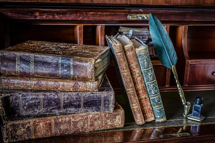 Livros antigos, encostados em prateleira